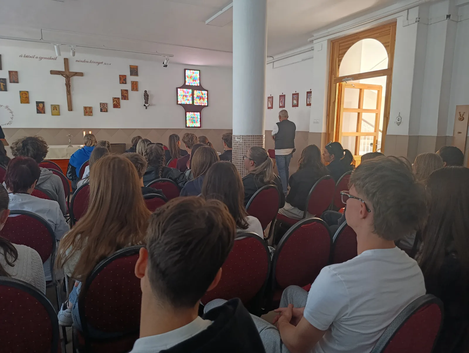 Az imádságra érkező diákok a kápolna padsoraiban